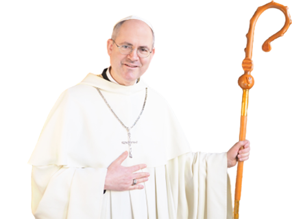Grüßender Abt Pius in weißer Robe mit einer silbernen Kreuzhalskette