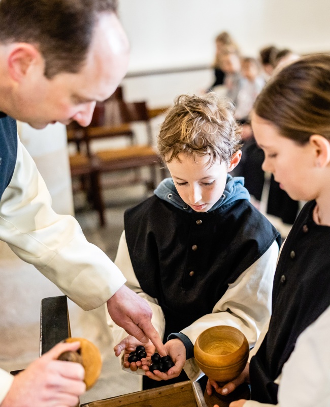 Children in monks dress with black pearls