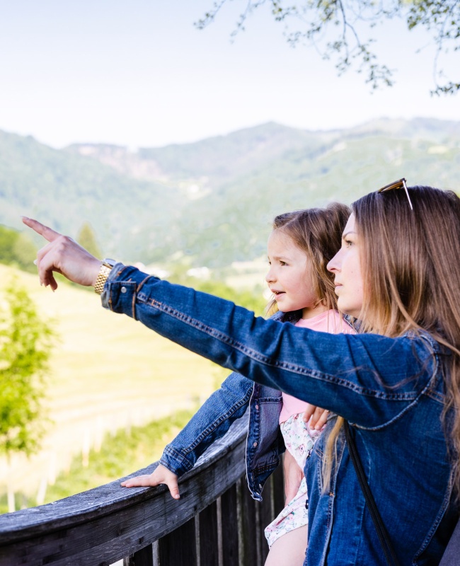 Mother with girl in nature pointing on something in the distance